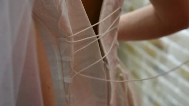 Lacing the brides dress. — Stockvideo