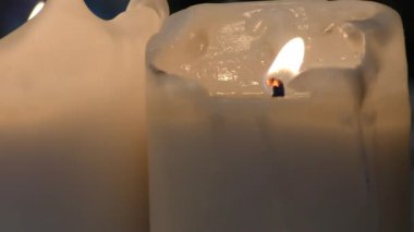 İki hafıza mumu karanlıkta yanar. Umudun ve maneviyatın ateşi.