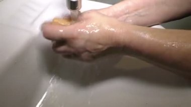 Yaşlı bir kadın kendini koronavirüs COVID-19 'dan korumak için ellerini yıkıyor. Yaşlı bir kadın kendini Coronavirus COVID-19 'dan korumak için ellerini yıkıyor..