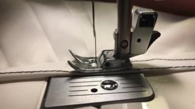 İşçi dikiş makinesine bez dikiyor.