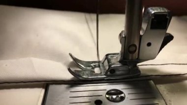 İşçi dikiş makinesine bez dikiyor.