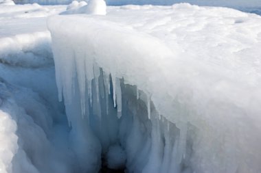 Kışın donan güzel doğa suyu. Manzara karlı ufka doğru genişliyor harika bir gökyüzü ve bulutlarla.
