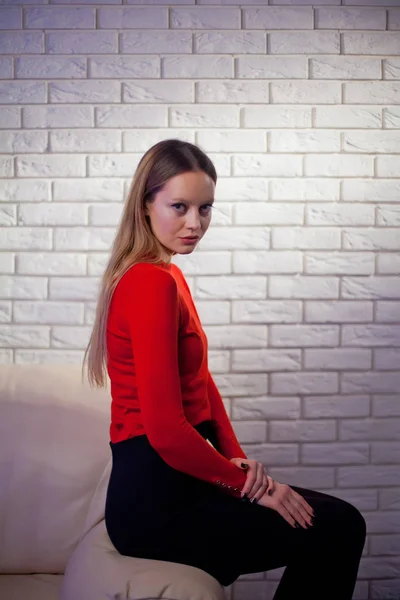 Молода жінка в червоній блузці біля цегляної стіни Стильний модний мод — стокове фото