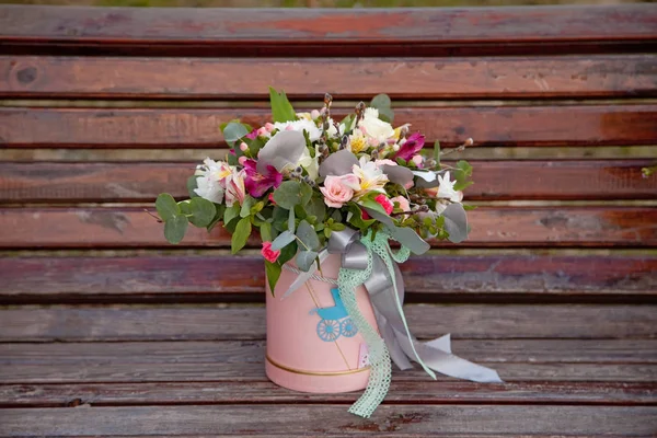 Schöner zarter Blumenstrauß in rosa Schachtel auf hölzernem Backgr — Stockfoto