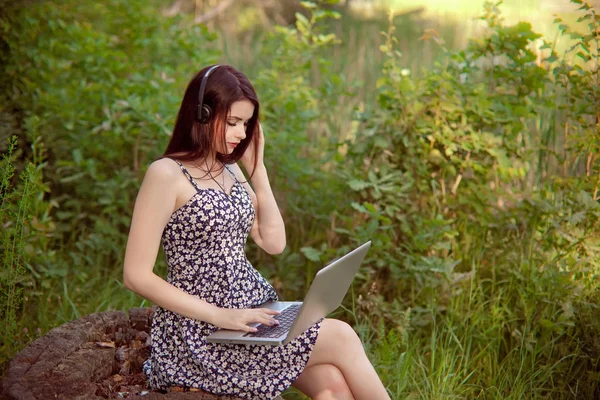 Brunett kvinna talar i ett videosamtal på linjen på naturen — Stockfoto