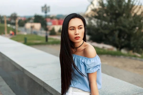 Hermosa mujer asiática joven con el pelo largo descansando en el parque —  Fotos de Stock