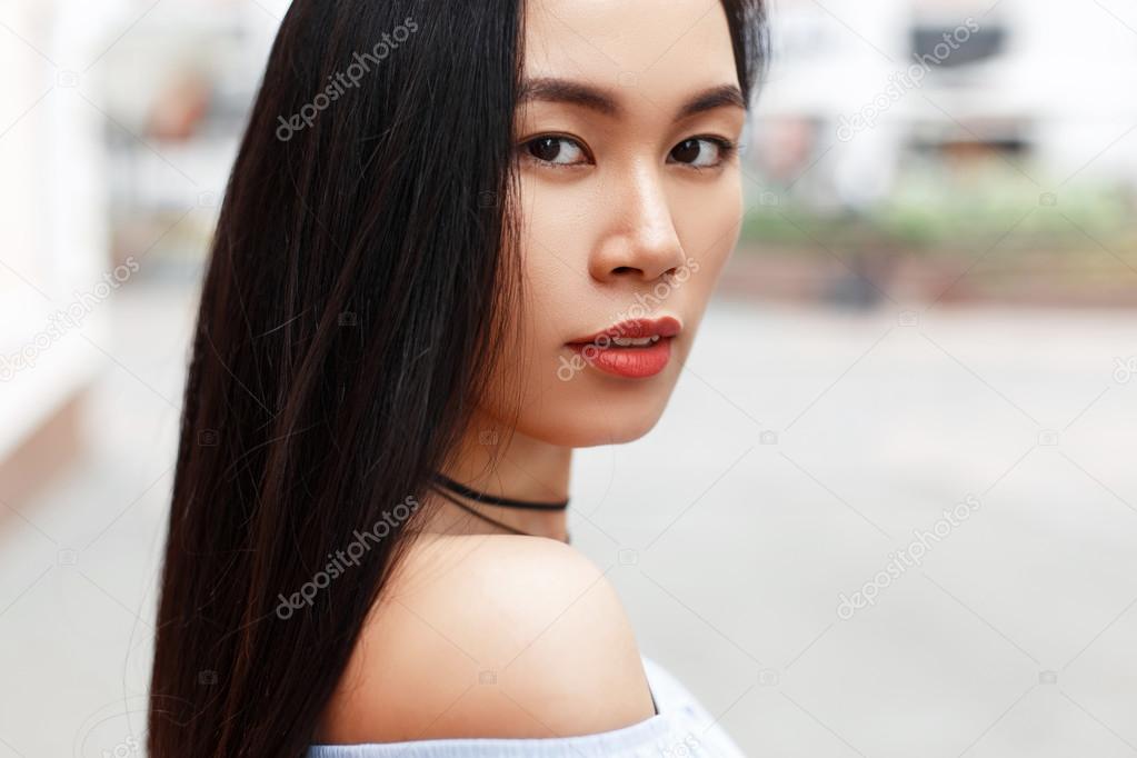 outdoors portrait of a beautiful Asian girl on the background of the city.
