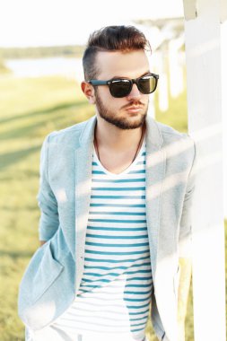 Bir ceket yakışıklı hipster adam, güneşli bir günde bir yaz t-shirt ve güneş gözlüğü.