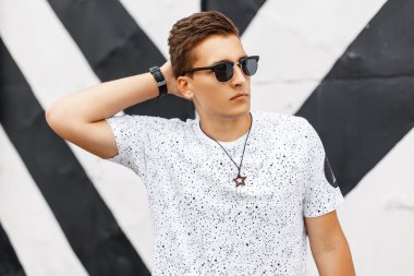 Şık yakışıklı adam arka plan satırlarında poz güneş gözlüğü