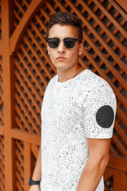 Ahşap duvar bir arka plan üzerinde beyaz bir gömlek genç şık yakışıklı adam