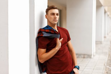 Holding bir gömlek ve beyaz wal ayakta yakışıklı delikanlı