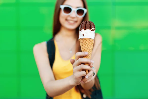 Menina bonita alegre sorrindo e segurando um sorvete. Delicioso cone de sorvete closeup . — Fotografia de Stock