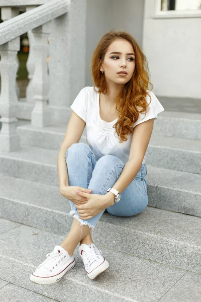 Mujer bonita joven en ropa de moda sentada en las escaleras en casa — Foto de Stock