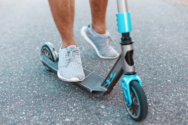 Gros plan d'un scooter sur l'asphalte. Coup de pied. Homme scooter équitation — Photo