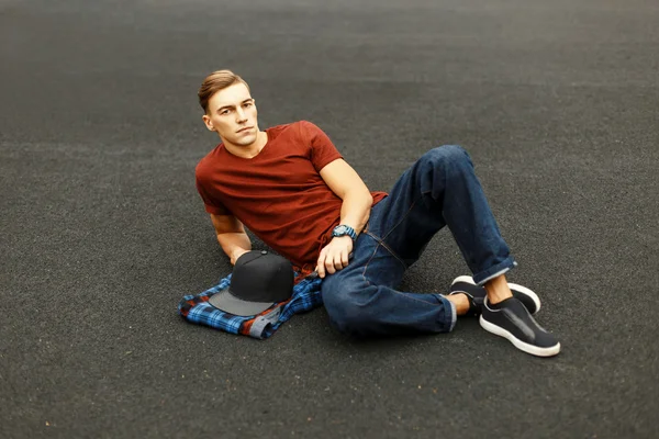 Bonito homem elegante está descansando no pavimento . — Fotografia de Stock