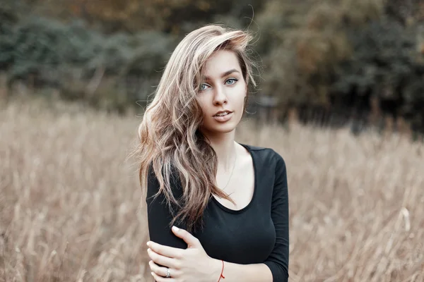 Hermosa modelo de niña en camiseta negra posando en el campo de maíz — Foto de Stock