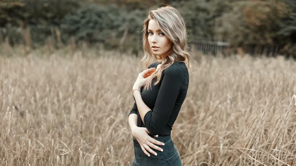 Sexy junge Frau im schwarzen Hemd steht in einem Maisfeld — Stockfoto
