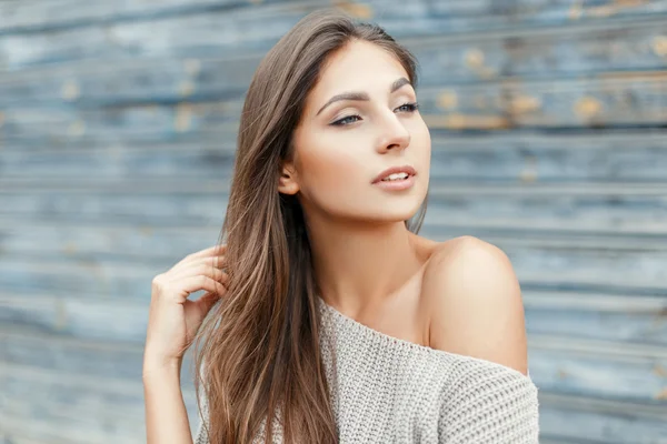 Sexy jeune belle femme dans un pull gris vintage près du mur en bois bleu — Photo