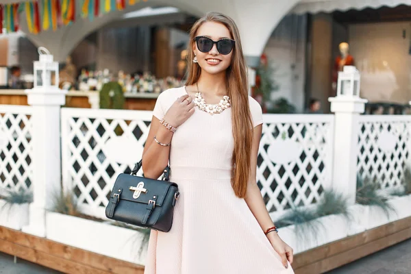 Allegro ragazza in un abito rosa con borsetta si diverte — Foto Stock