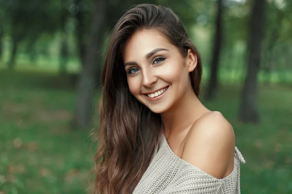 Piękna kobieta szczęśliwa z ładny biały uśmiech w szary sweter z dzianiny w parku — Zdjęcie stockowe