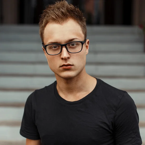 Joven hombre guapo con gafas en una camisa negra . — Foto de Stock