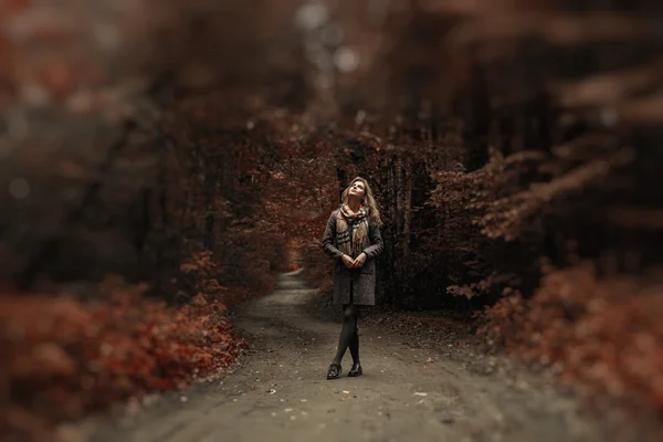 Young woman in coat and scarf walk in an amazing park — Stock Photo, Image