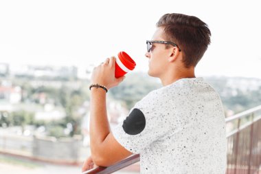 Yakışıklı hipster adam kahve içme ve şehre bakıyor