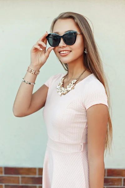 Szczęśliwy, piękna dziewczyna z uśmiechem w okulary w pobliżu ściany — Zdjęcie stockowe