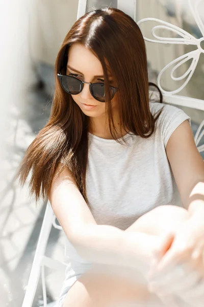 Portret piękne sexy dziewczyna w okulary, siedząc w fotelu na słoneczny dzień — Zdjęcie stockowe