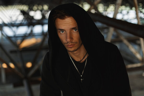 Красивый молодой человек в черном халате с капюшоном
.