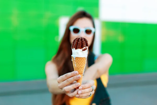 Beautiful young girl with ice cream on the street. Ice cream in hands