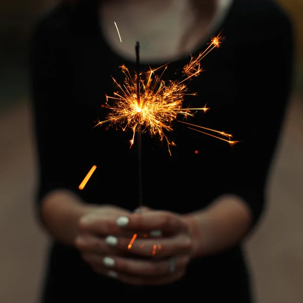 Menina segurando um sparkler — Fotografia de Stock