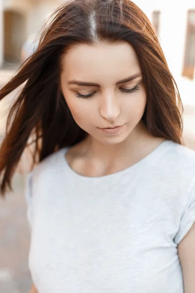 Modest beautiful girl looks down. Portrait of a pretty woman in a summer sunny day