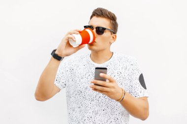 Yakışıklı adam kahve içiyor ve telefonunuzda bir mesaj okuyor.