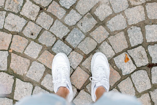 Jongeman reizen op zomervakantie. Witte sneakers op tegel. — Stockfoto