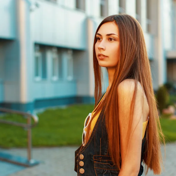 Krásná bruneta žena s dlouhými vlasy u moderní budovy — Stock fotografie