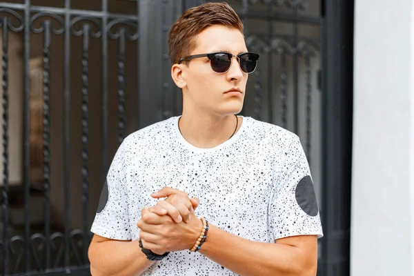 Yakışıklı adam ellerini ovuşturuyor. Dış mekan portresi