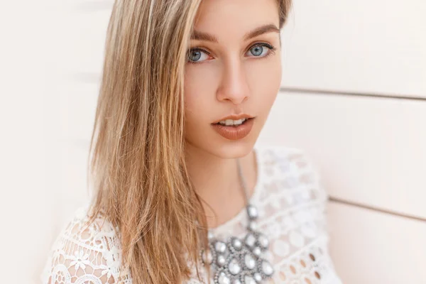 Ritratto di una bella ragazza bionda con gli occhi azzurri sullo sfondo di una parete di legno . — Foto Stock