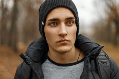 Bir siyah örme şapka ve kış ceket sonbahar parkta yakışıklı bir adam portresi.