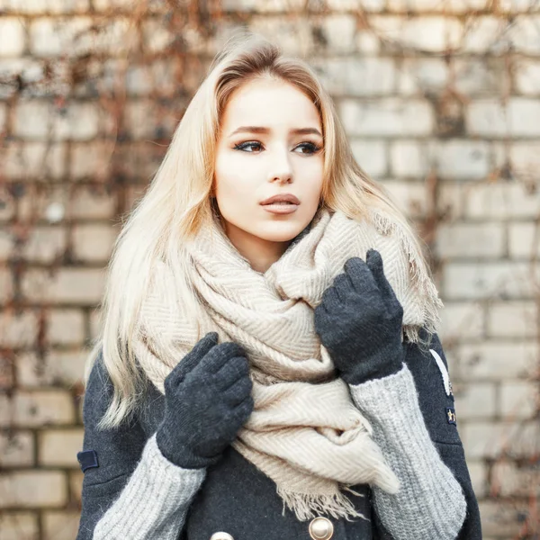 Menina bonita bonito com um lenço quente no fundo da parede de tijolo — Fotografia de Stock