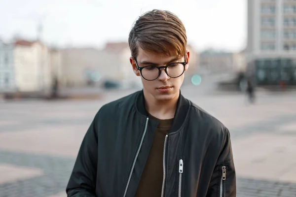 Joven guapo con gafas en el fondo de la ciudad — Foto de Stock