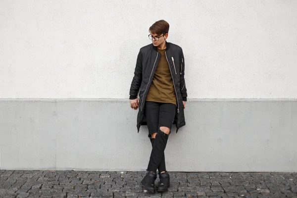 재킷과 찢어진된 청바지 벽 근처 포즈에서 세련 된 잘생긴 젊은 남자. — 스톡 사진