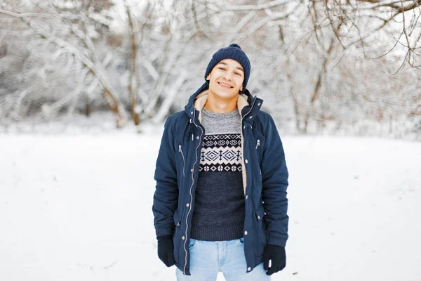Happy νεαρό άνδρα στα χειμερινά ρούχα και κομψά μοντέρνα πλεκτά πουλόβερ περπάτημα σε ένα πάρκο του χειμώνα. — Φωτογραφία Αρχείου