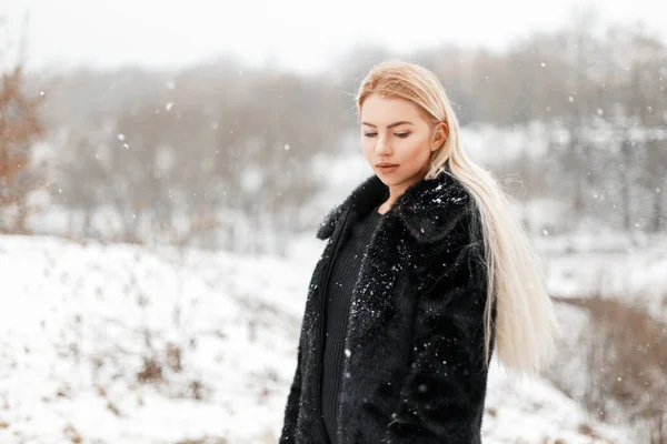 Menina loira bonita em casaco de pele posando no parque de inverno — Fotografia de Stock