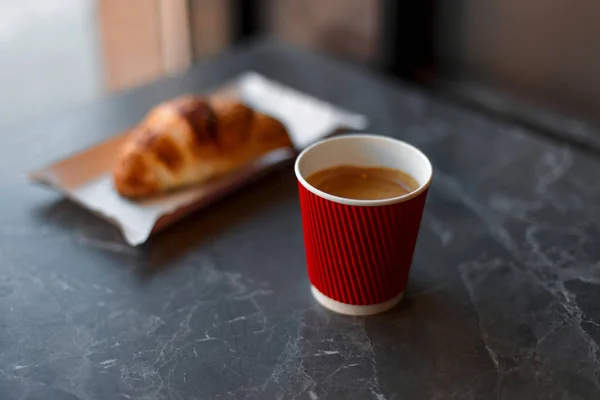 Heerlijke koffie in een rode kop met een croissant — Stockfoto