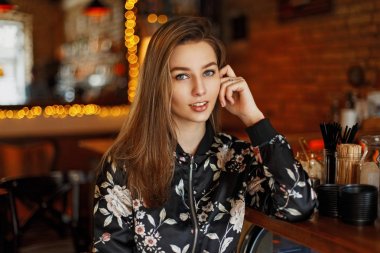 Bir gülümseme ile mutlu genç kadın bir kafede oturuyor