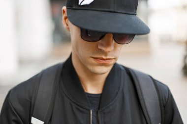 Beysbol şapkası ve siyah gözlük genç bir adam portresi