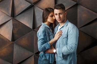 Ahşap modern duvara yakın sarılma şık denim giysiler içinde güzel Çift