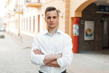 Yakışıklı adam Yöneticisi bir beyaz gömlek saç modeli ile şehrin onun kollarında geçti