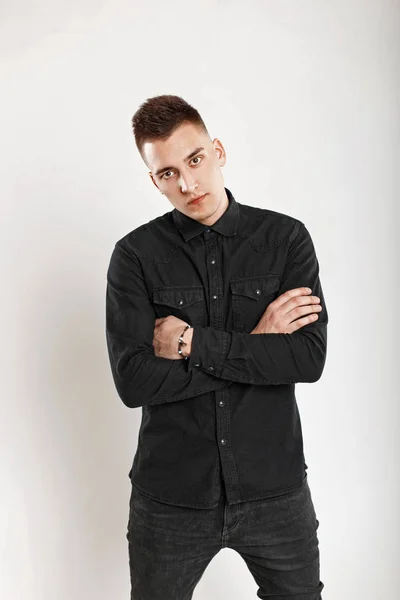 Young handsome man in a black shirt in the studio — Stock Photo, Image